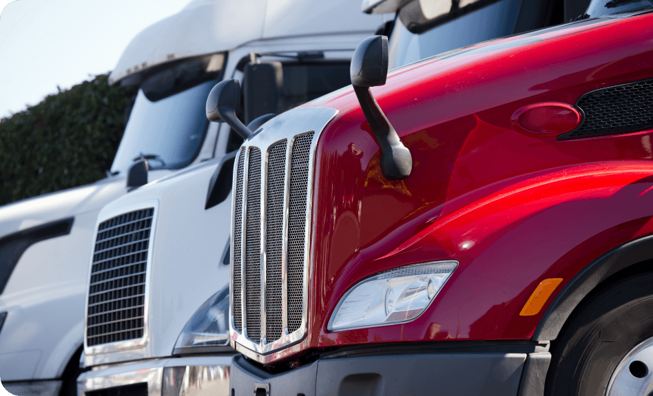 shutterstock_757603897 An image of a red cab in the foreground with other trucks beside it.