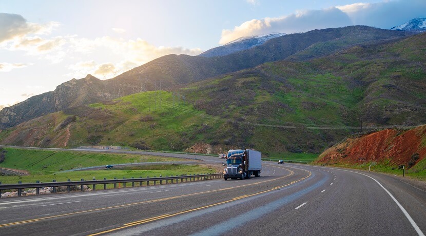 A semi truck driving on a mountain road.