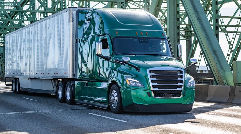 A tractor-trailer crossing a truss bridge.